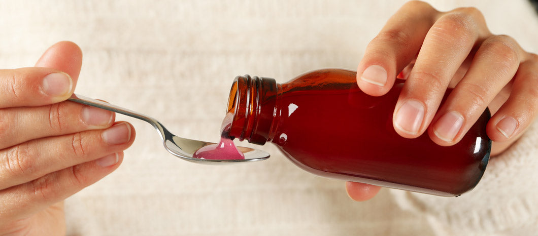 woman pouring cough syrup on spoon for fertility use