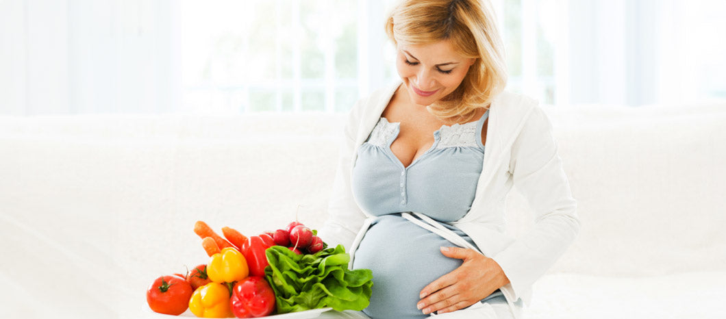 pregnant woman next to vegetables for immunity support