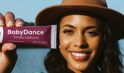 woman holding up a tube of BabyDance fertility lubricant