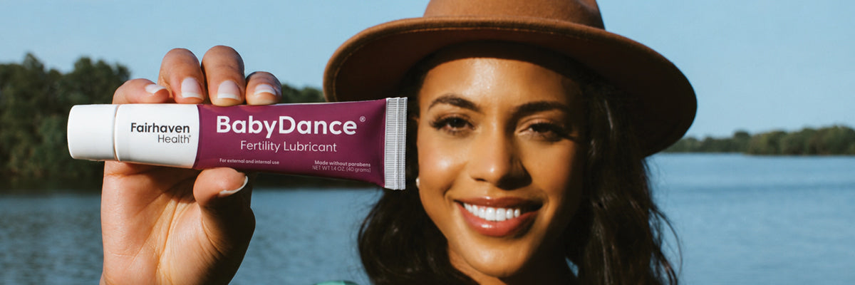woman holding up a tube of BabyDance fertility lubricant