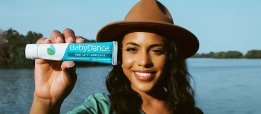 woman holding up a tube of BabyDance fertility lubricant