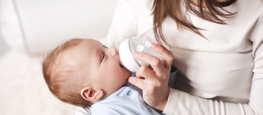 mother feeding baby with milk bottle