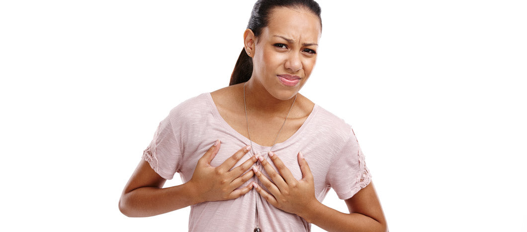 woman wincing and holding breast due to pain