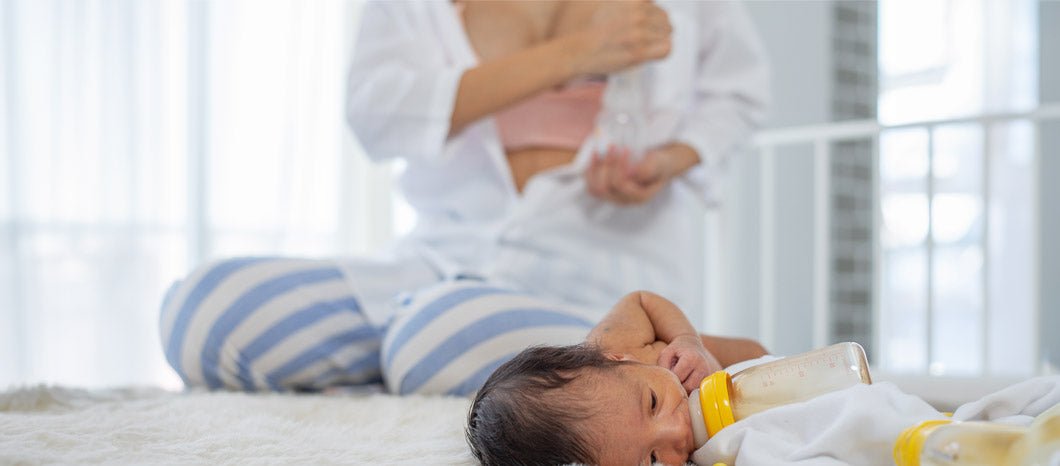 woman pumping breast milk while baby is feeding