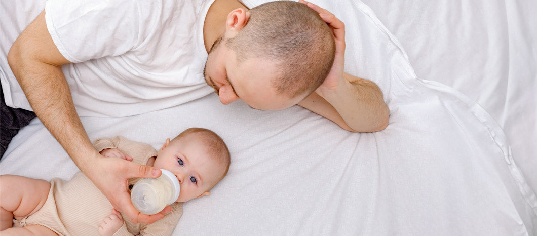 dad feeding baby with bottle