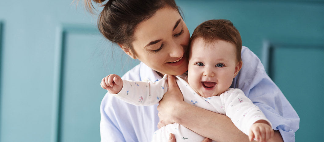 happy mother holding baby before breastfeeding