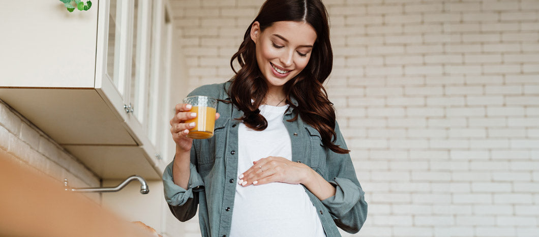 happy pregnant woman looking at belly