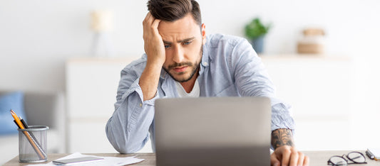 frustrated man looking for answers on computer for fertility issues
