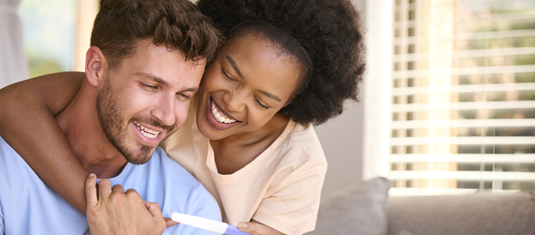 happy couple looking at results of pregnancy test