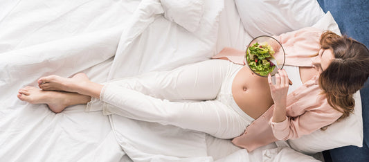 pregnant woman eating healthy in bed