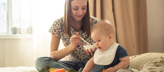 mother feeding baby solid foods