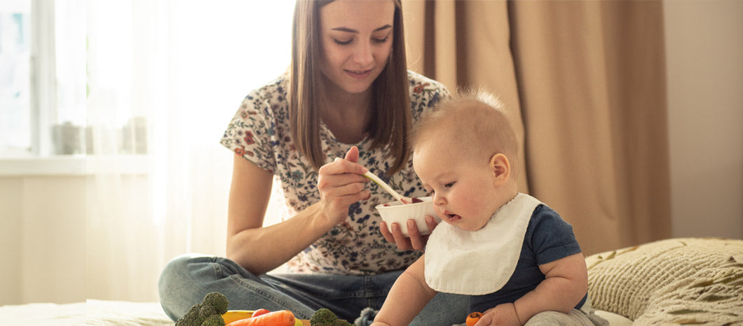 mother feeding baby solid foods