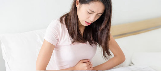 woman holding stomach due to menstrual cramps