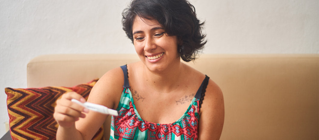 woman smiling holding ovulation test