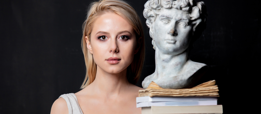woman next to greek statue and books