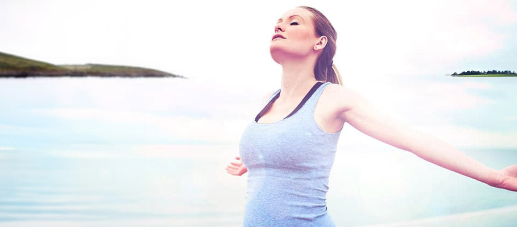 woman stretching her arms by the water