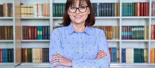 woman teacher in front of book shelf ready to teach